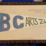 A pennant borne by a UBC Arts student during the “Great Trek” of October 1922 (then known as “The Pilgrimage”), when UBC students walked from downtown Vancouver to the site of UBC’s new campus in Point Grey, to draw public attention to the need to complete the work that had begun in 1914. The accompanying photograph was taken by Orson Banfield; see the article by his granddaughter Carla Banfield at https://dev.legacies.alumni.ubc.ca/2621-2/.